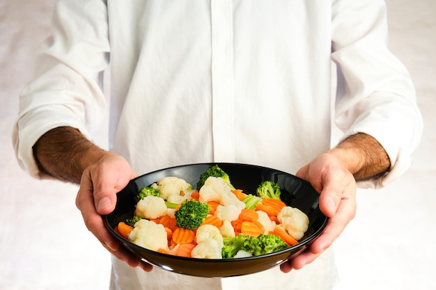 Kucharz trzymający talerz gorącego dania